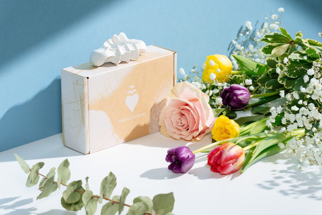 eine box, blumen und ein 3d handabdruck als personalisiertes Muttertagsgeschenk